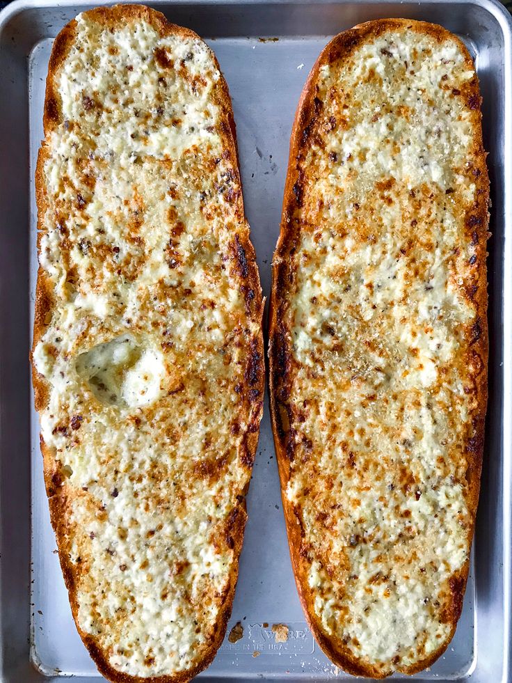 two pieces of bread with cheese on them in a pan, ready to be cooked