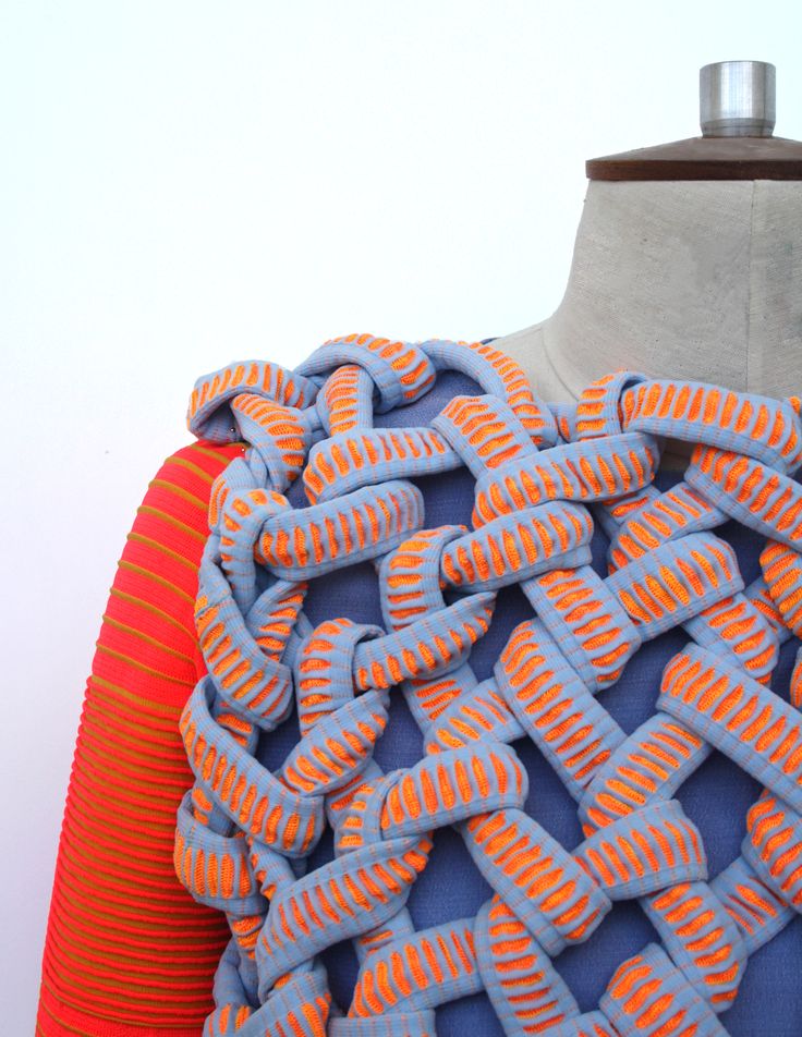 an orange and blue dress on a mannequin's torso with wavy lines