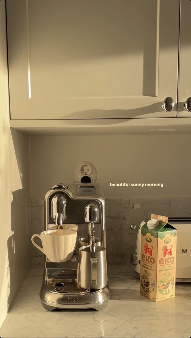 a coffee maker sitting on top of a counter next to a carton of milk