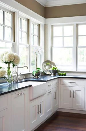 a kitchen with white cupboards and black counter tops is seen on the phone screen