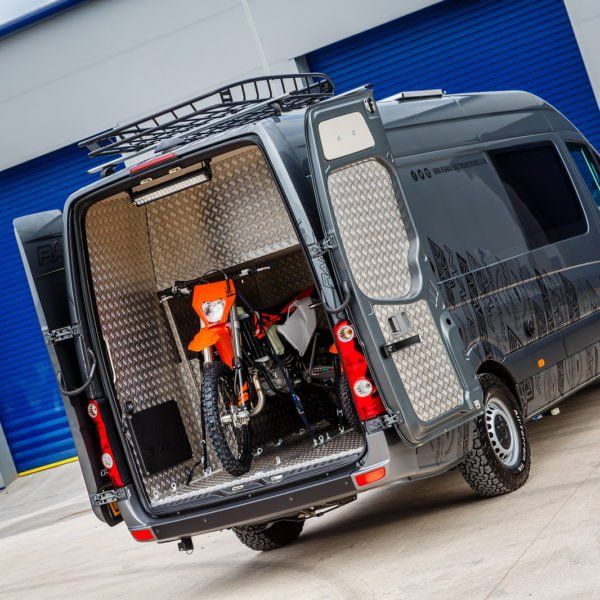 a van with its doors open and two bicycles in the back