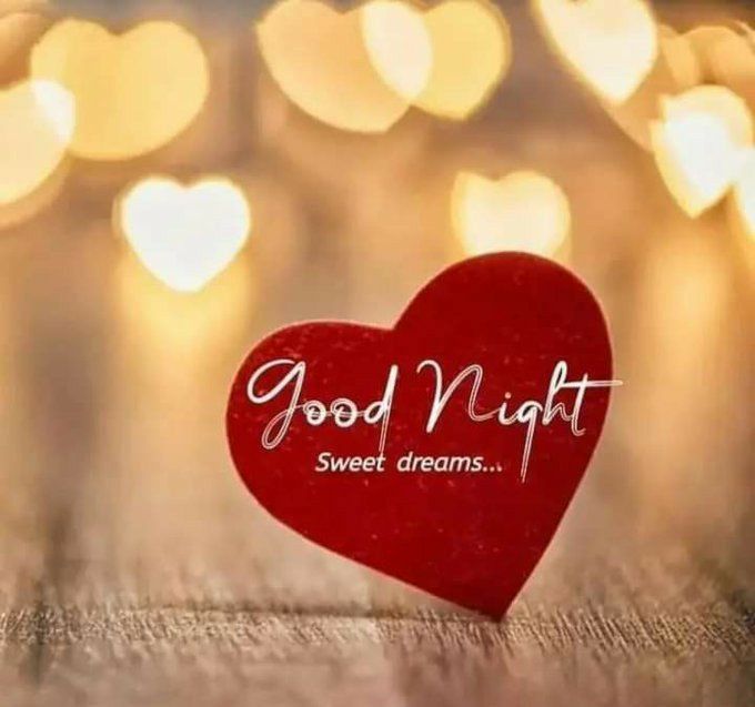 a red heart with the words good night sweet dreams written on it and lights in the background