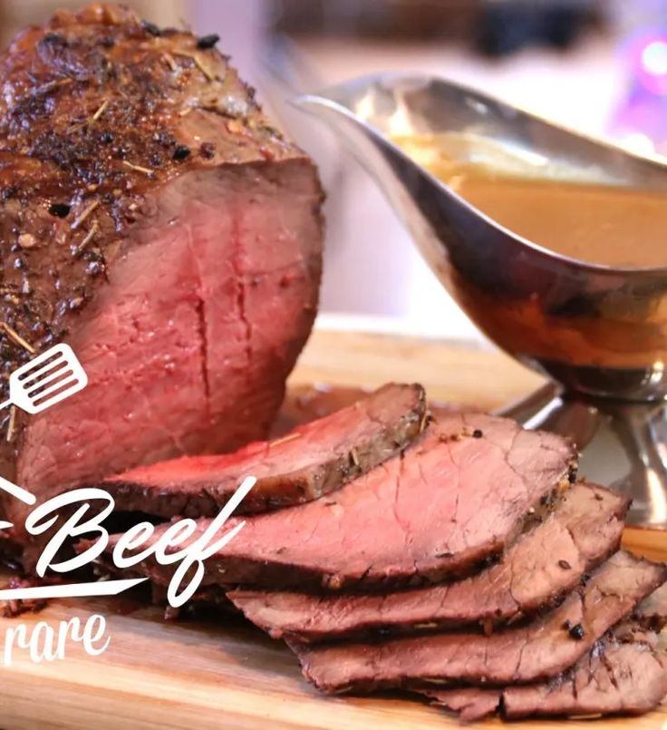 the beef is sliced and ready to be served on the table with sauce in a bowl