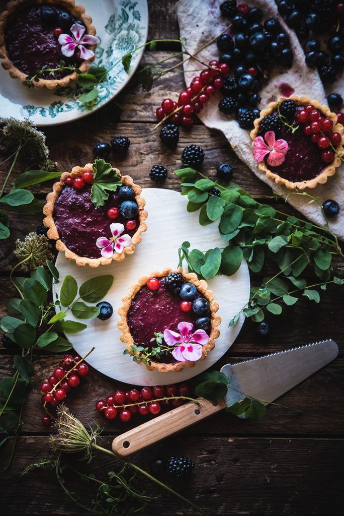 some pies with berries and blueberries on them