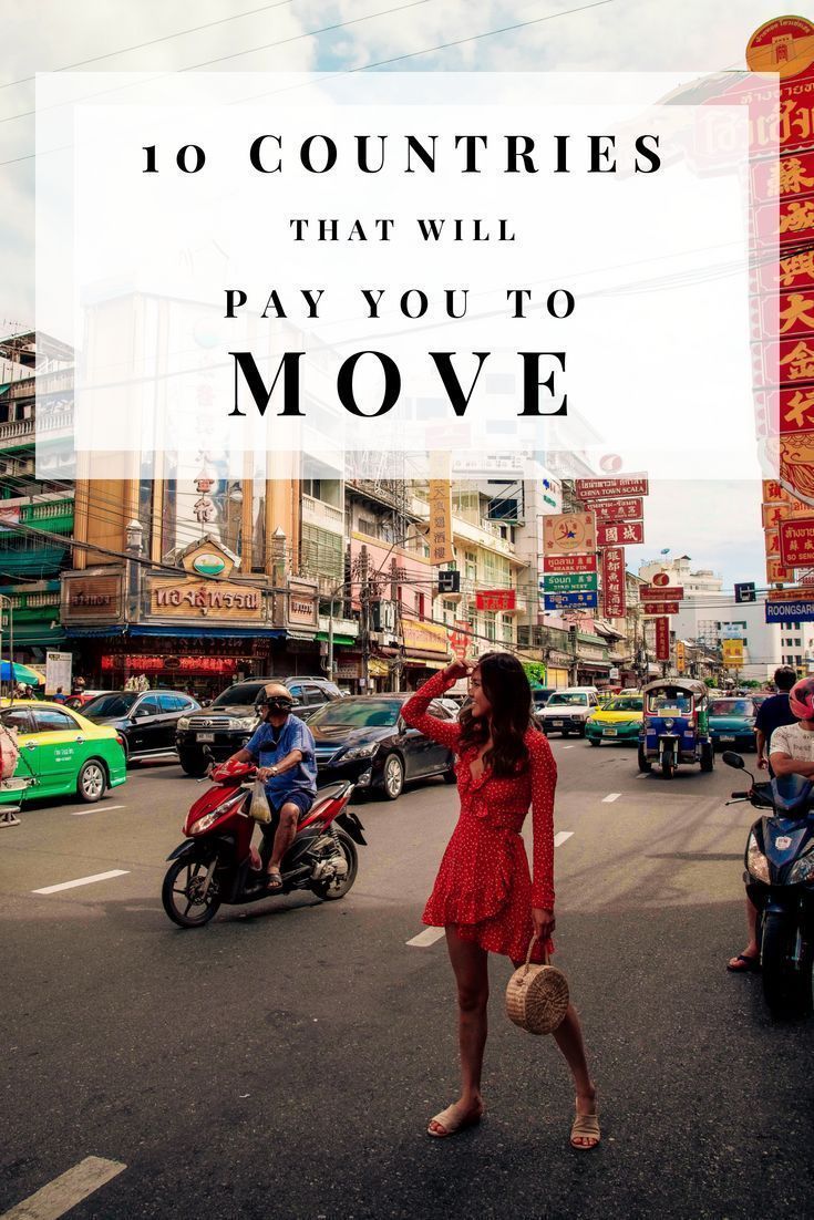 a woman in a red dress is walking down the street with cars and motorcycles behind her