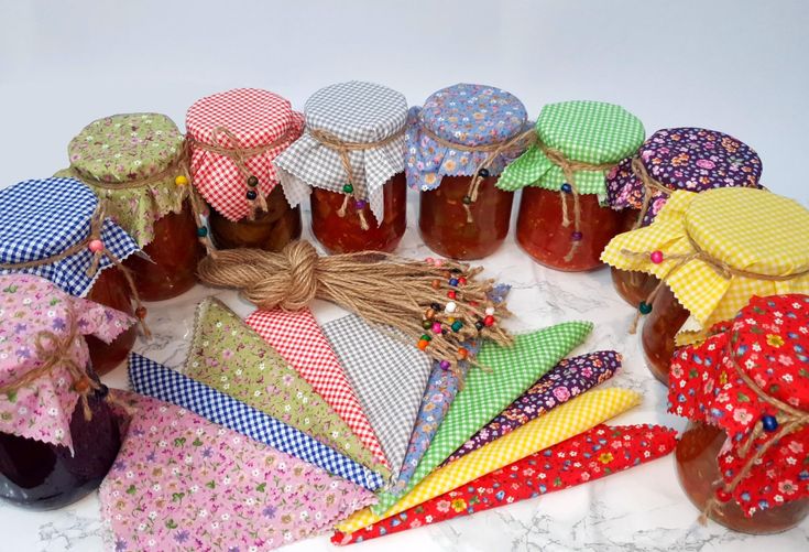 there are many jars and ties on the table with jams in them, all tied together