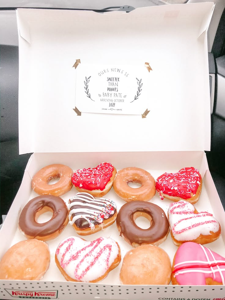 a box filled with lots of donuts covered in frosting and sprinkles