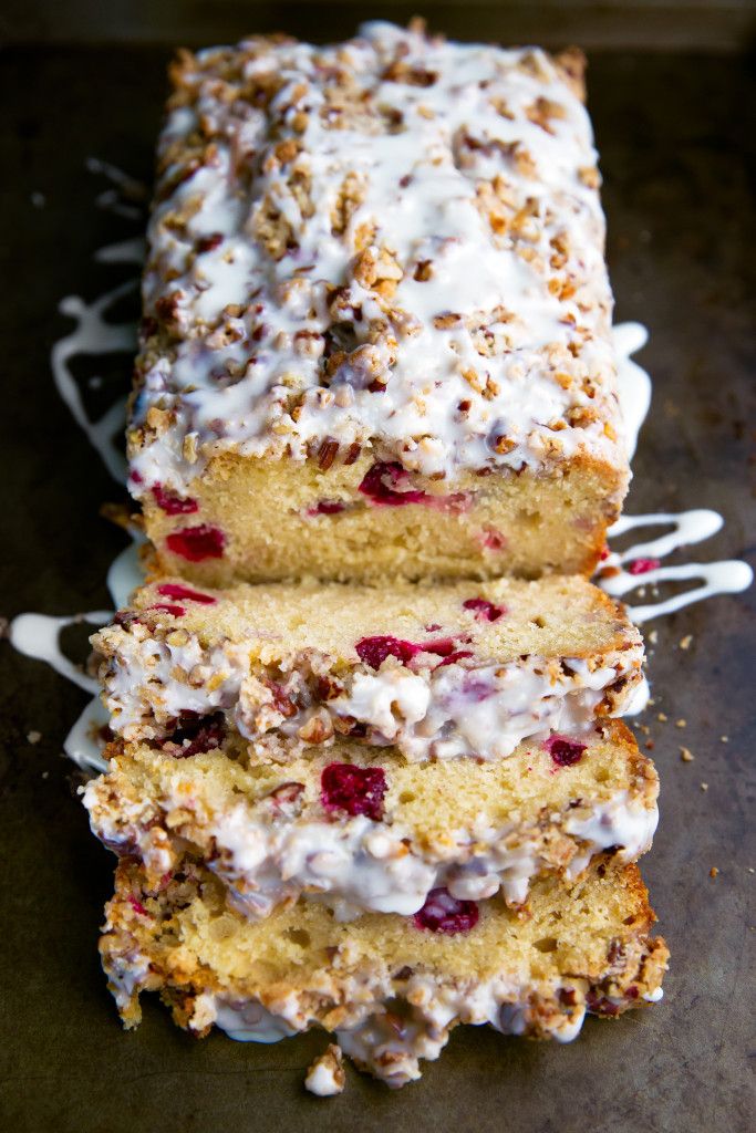 a loaf of cake with white icing and cranberries