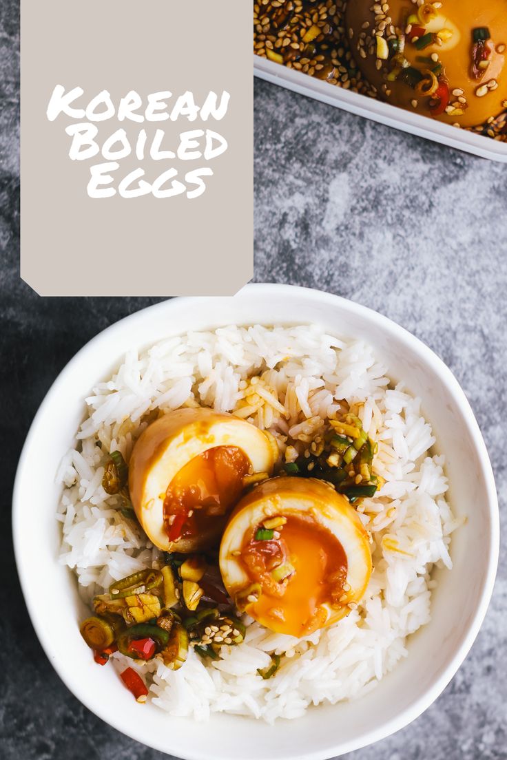 a bowl filled with rice and boiled eggs on top of a table next to another bowl