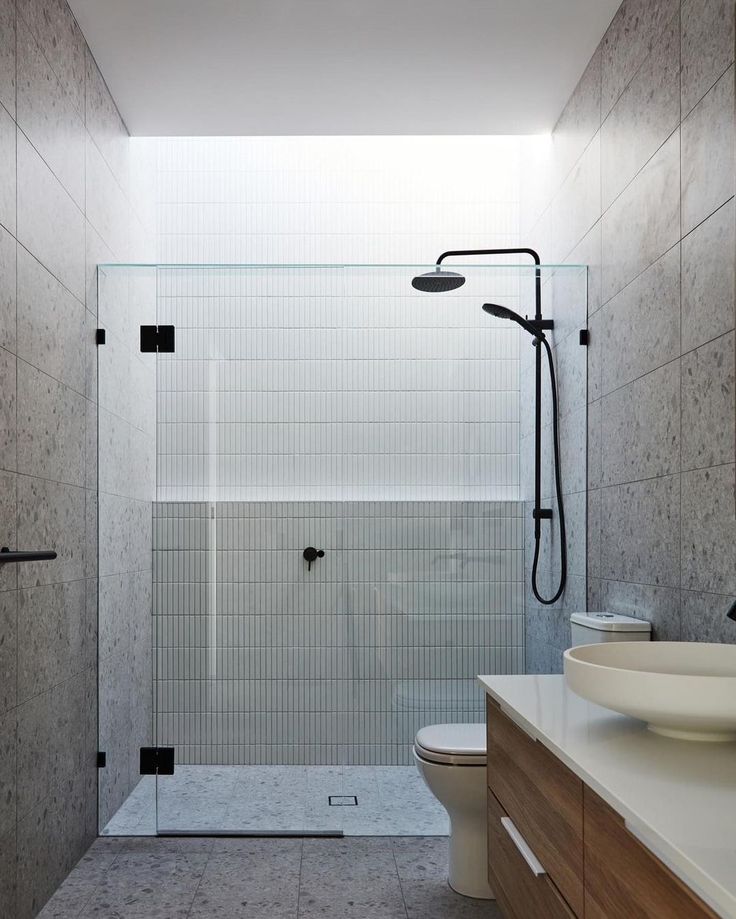 a bathroom with a sink, toilet and shower stall in the middle of the room