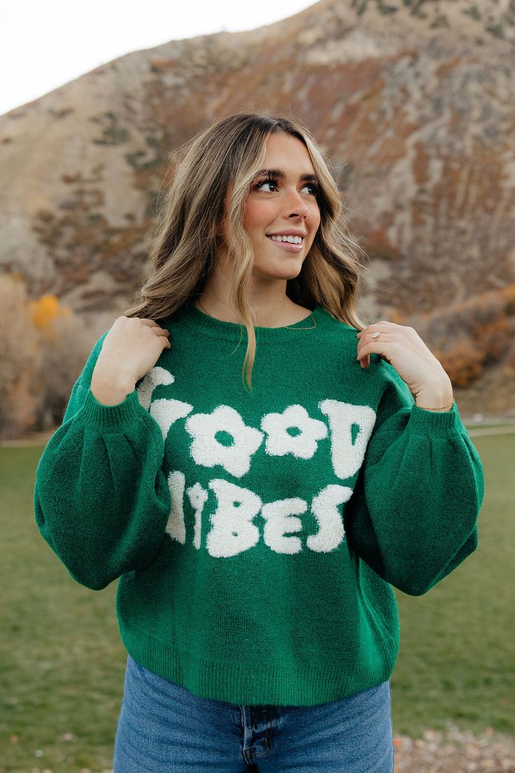 THIS SALE ITEM IS FINAL SALE Stay warm in style with this relaxed fit, knitted sweater in Hunter Green. The perfect addition to any wardrobe, its playful "good vibes" wording adds a touch of playfulness and whimsy. Show off your fun side and spread some joy! *Relaxed fit* Material Content: 74% Acrylic // 22% Polyester // 5% Spandex Material Pattern: Knitted Taylor is 5'8" wearing a small Model Measurements: Taylor: Height: 5'8" // Chest: 34" // Waist: 27" // Hips: 38" Click here for denim Not su Relaxed Fit Knit Sweater With Graphic Print, Knit Sweater With Graphic Print In Relaxed Fit, Playful Crew Neck Fall Sweater, Playful Crew Neck Sweater For Fall, Playful Soft Knit Sweater For Fall, Trendy Knit Sweater With Graphic Print, Cozy Spring Sweater With Letter Print, Cozy Letter Print Sweater For Spring, Playful Green Sweater With Crew Neck