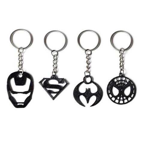 three different key chains with superman and spider - man symbols on them, one is black