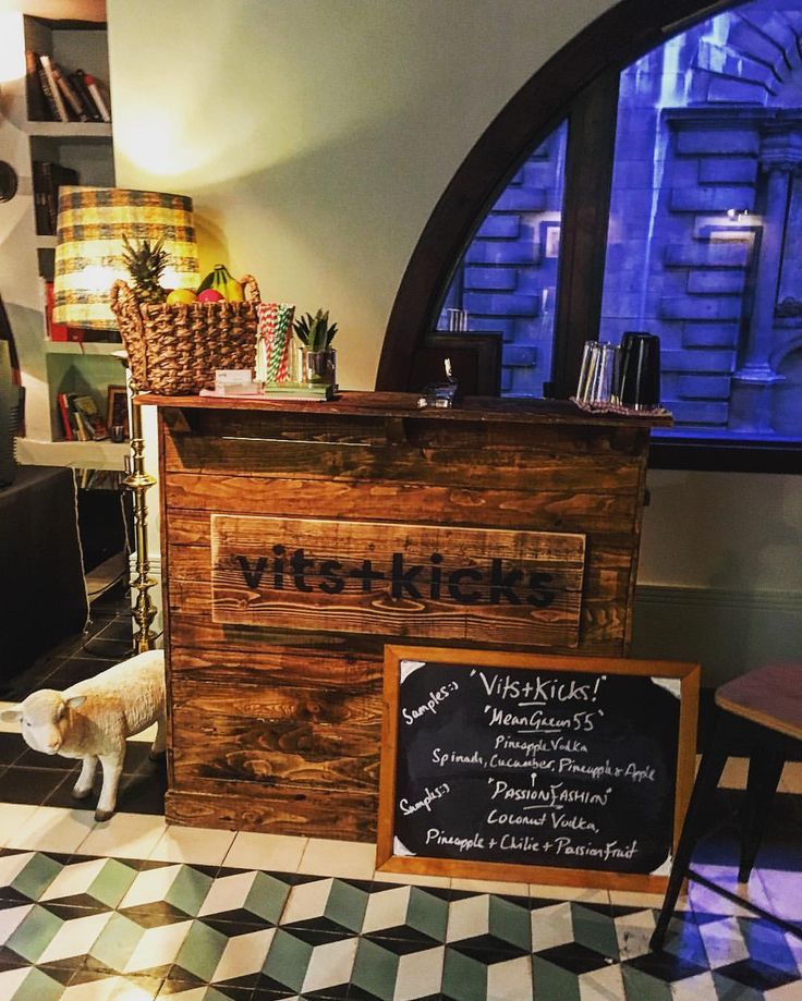 a small wooden counter sitting in front of a black and white checkerboard floor