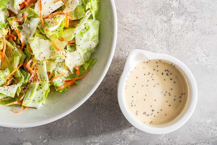 a salad with dressing in a bowl next to it