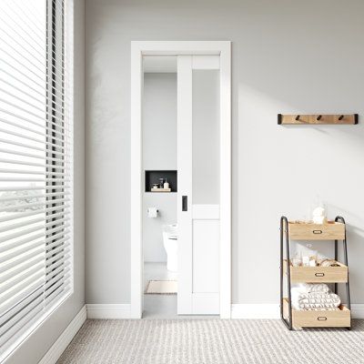 a bathroom with white walls and flooring next to a toilet in a room that has two wooden shelves on the wall