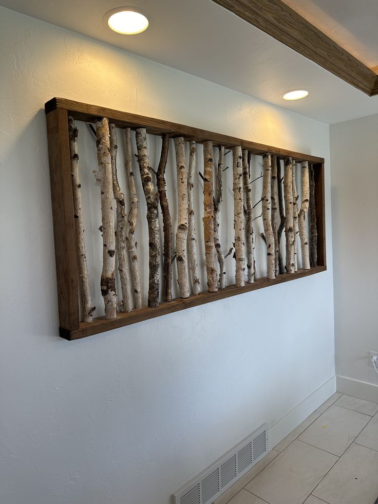 a bathroom with white tile and wooden paneled wall art on the wall next to a toilet