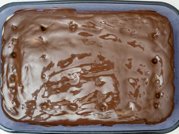 a pan filled with chocolate frosting sitting on top of a counter