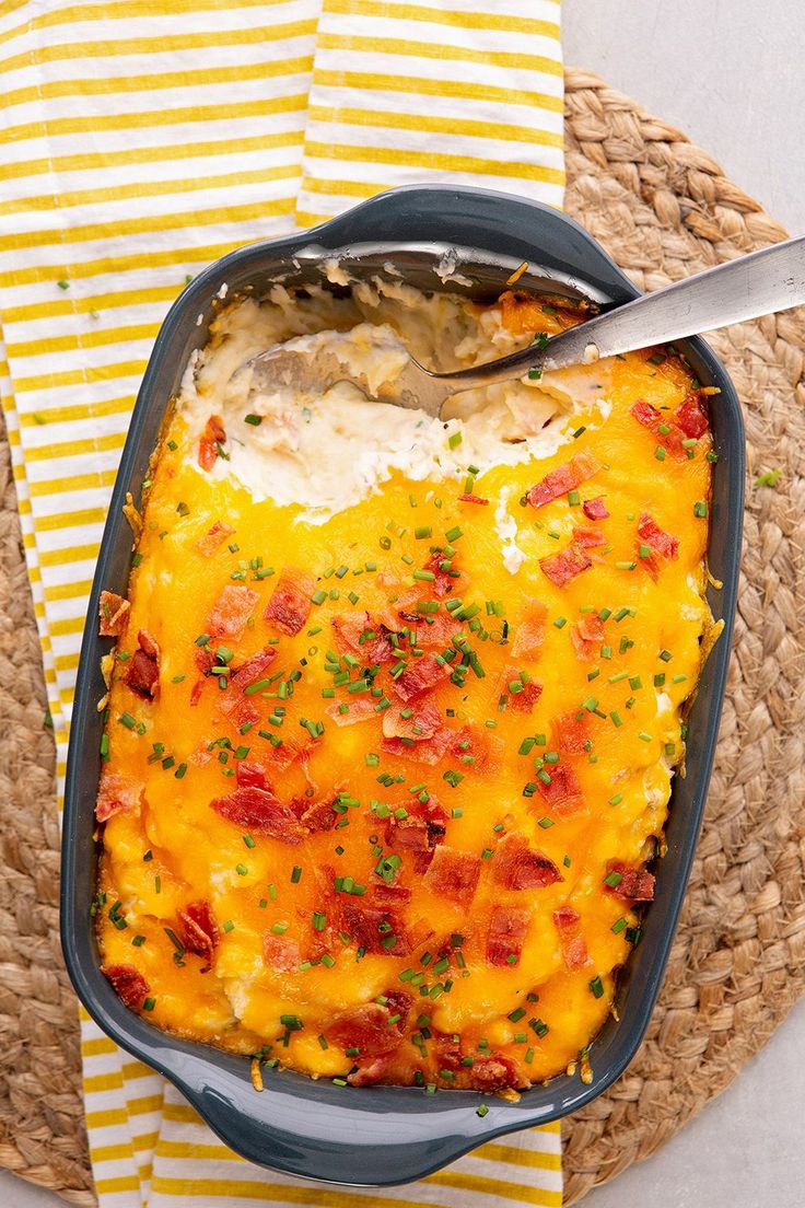 a casserole dish with meat and cheese in it on a yellow and white napkin