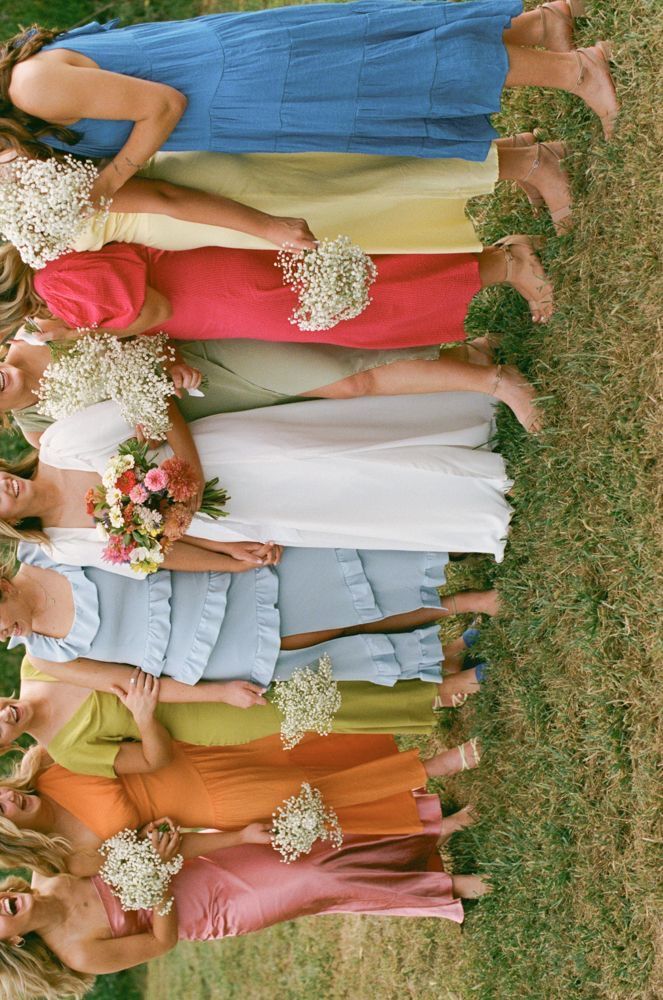 a group of women standing next to each other on top of a lush green field