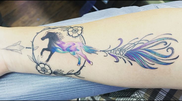 a woman's arm with a tattoo on it that has a horse and flowers