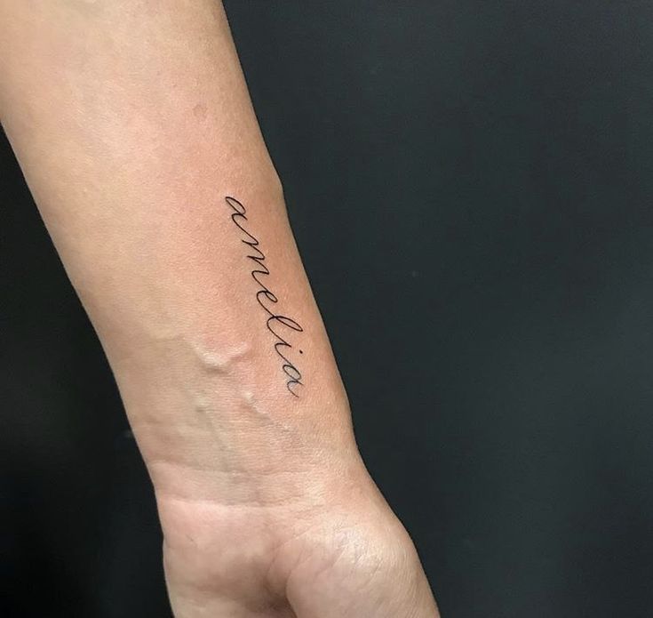 a woman's arm with the word love written on it in cursive writing