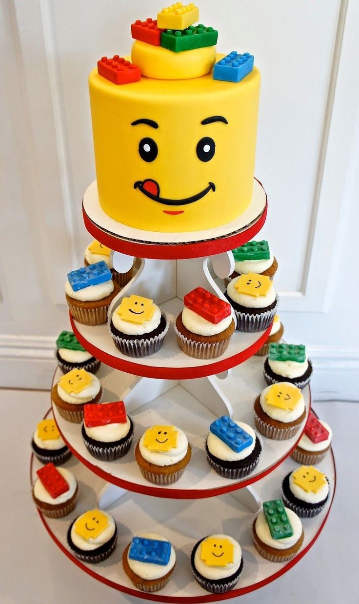 a three tiered cake with lego cupcakes on it