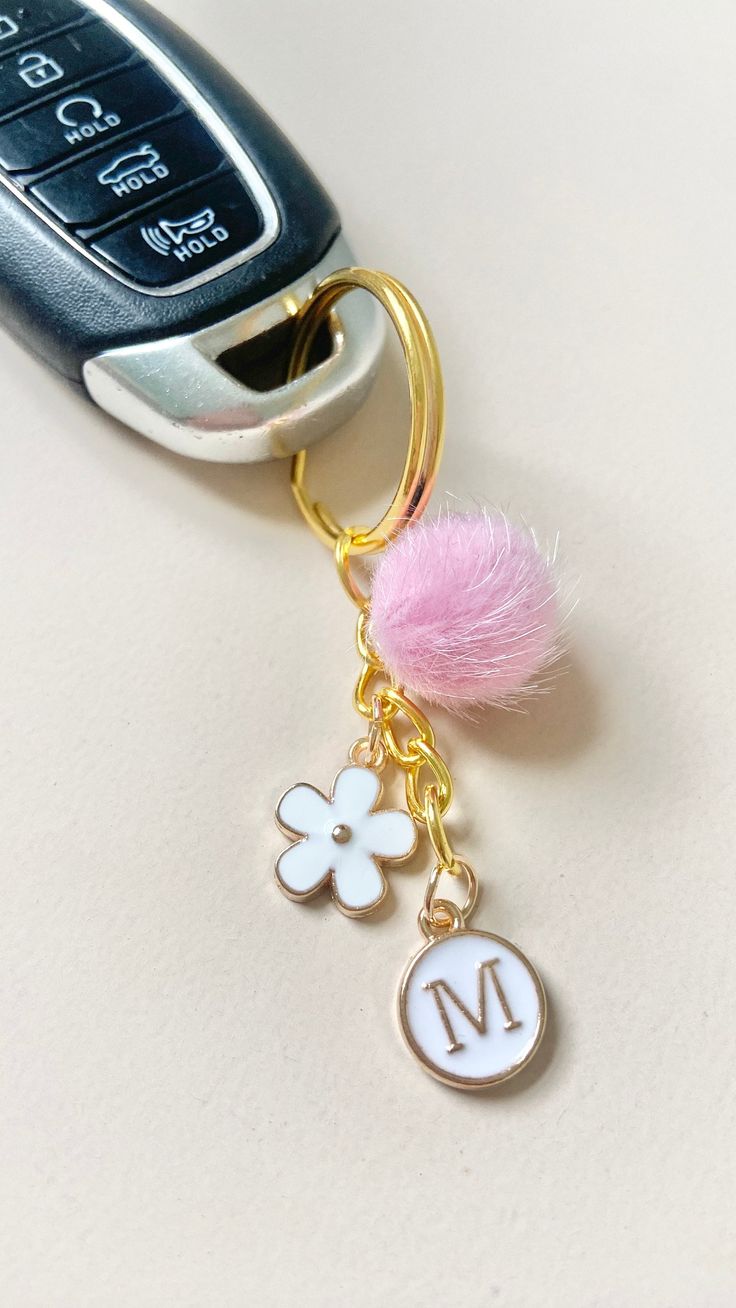 a car keychain with a pink pom - pom attached to it