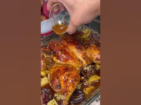 someone is pouring wine into a roasting pan full of chicken