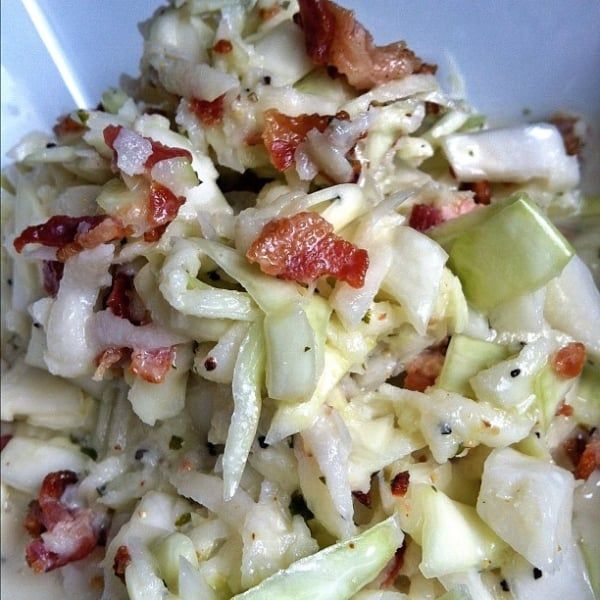 a white plate topped with cabbage and bacon