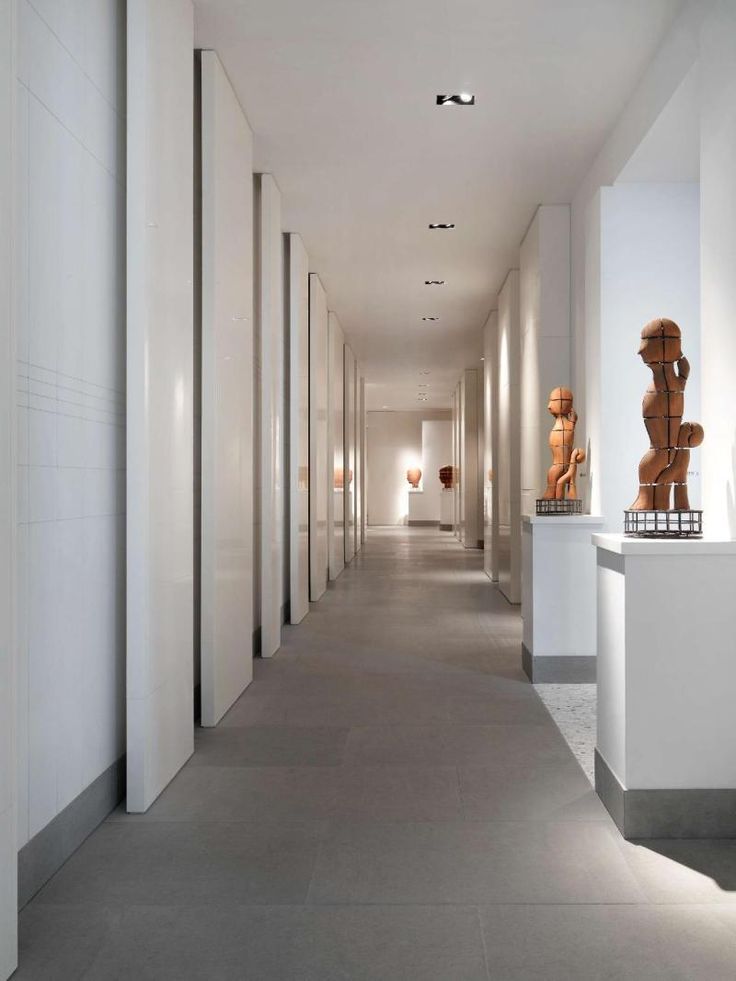 a long hallway with sculptures on either side