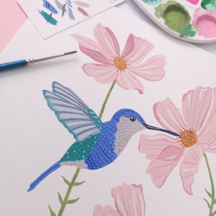 a painting of a hummingbird with pink flowers and watercolor paints next to it