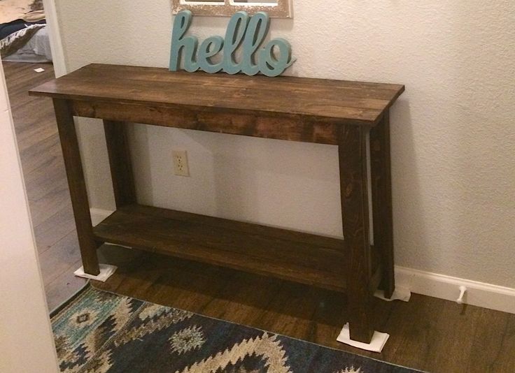 a wooden table with the word hello spelled on it in front of a white wall