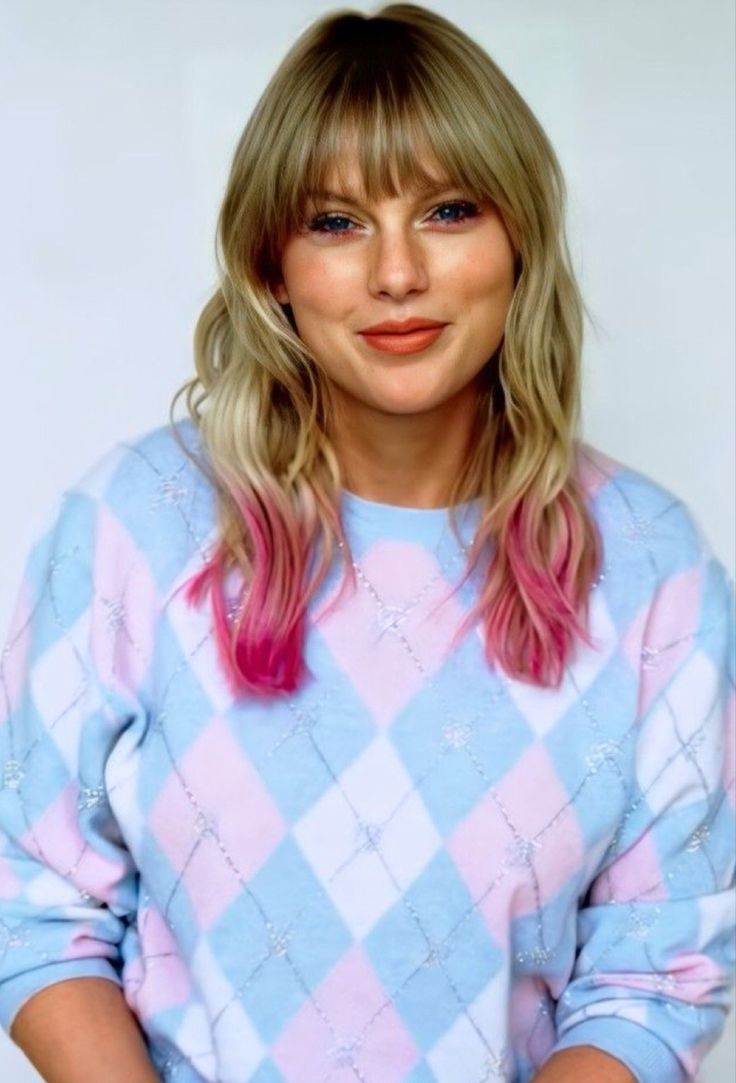 a woman with pink hair and blue sweater