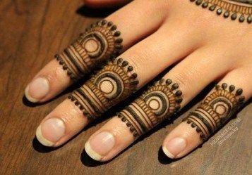 a woman's hand with hennap on it and some beads around her fingers