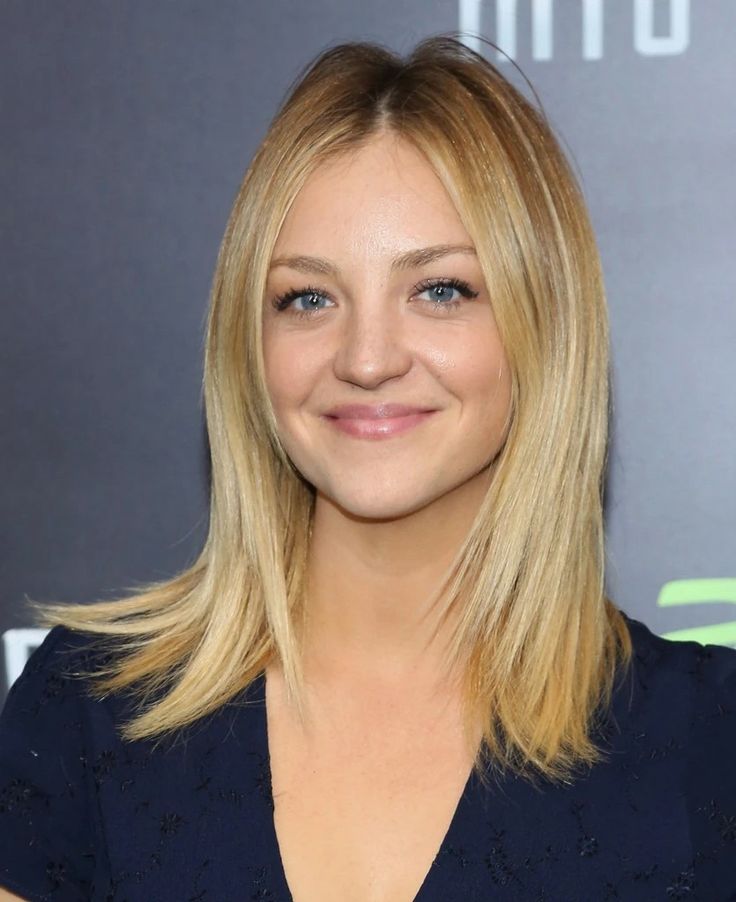 a woman with blonde hair smiling at the camera