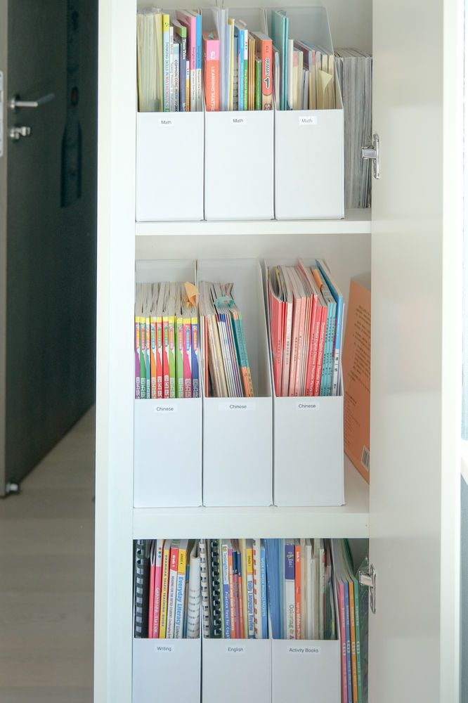 a book shelf filled with lots of books next to a door and window sill