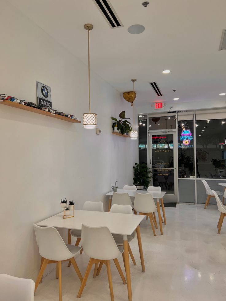 an empty restaurant with white tables and chairs