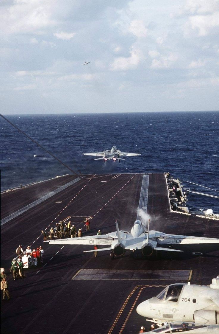 an airplane on the flight deck of an aircraft carrier in the middle of the ocean