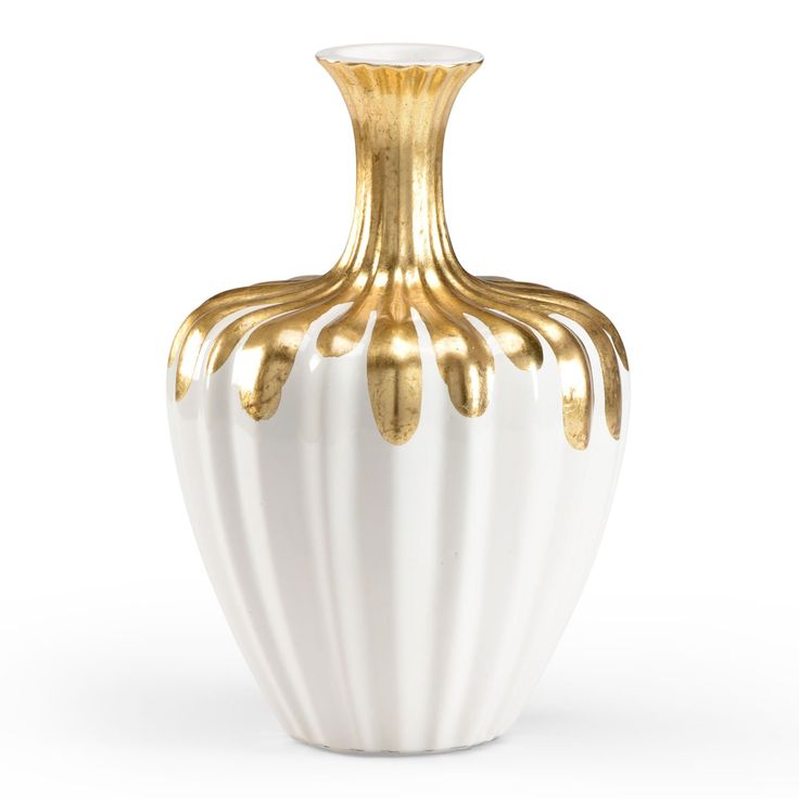 a white and gold vase sitting on top of a table