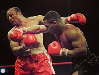 two men are boxing in the ring with each other