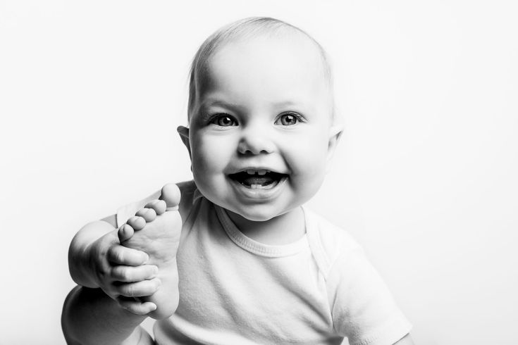 a black and white photo of a smiling baby