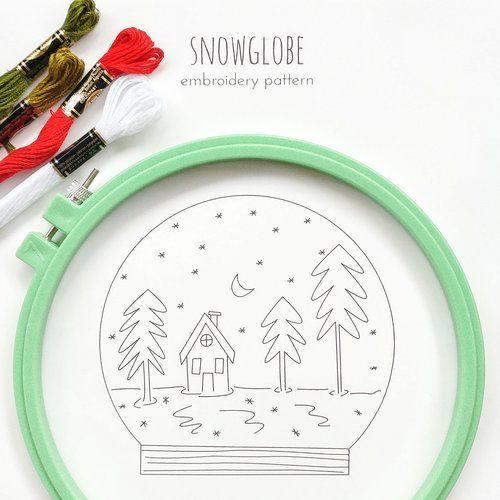 the embroidery pattern is being worked on with scissors and yarns to make a snow globe