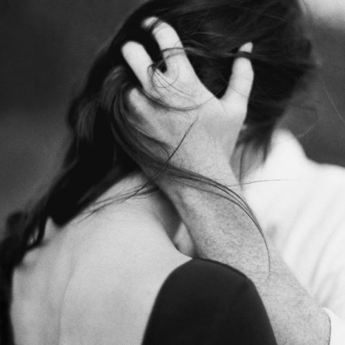 a black and white photo of a woman holding her hands to her face while she covers her ears