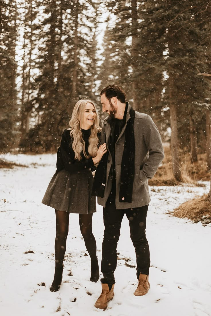 a man and woman standing in the snow