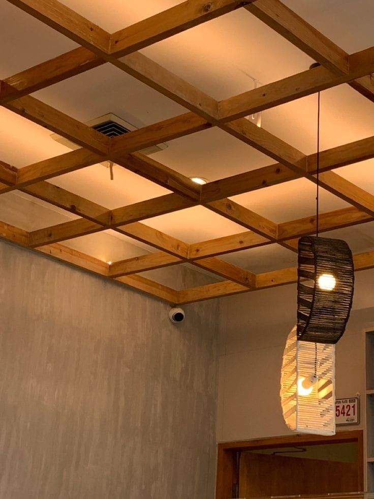 a room that has some lights hanging from the ceiling and wood beams on the ceiling