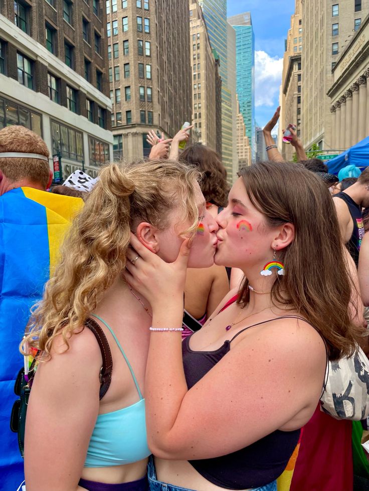 two women kissing each other in the middle of a crowd