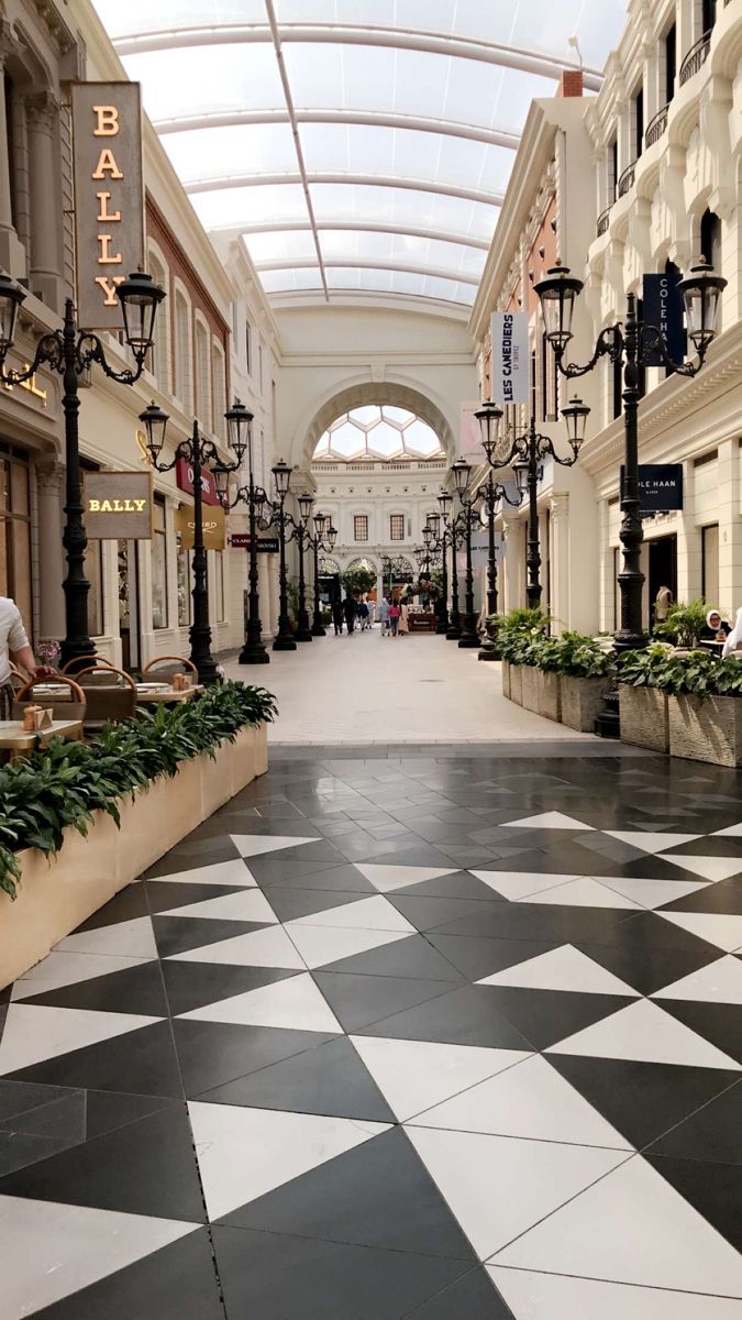 an empty shopping mall with black and white tiles