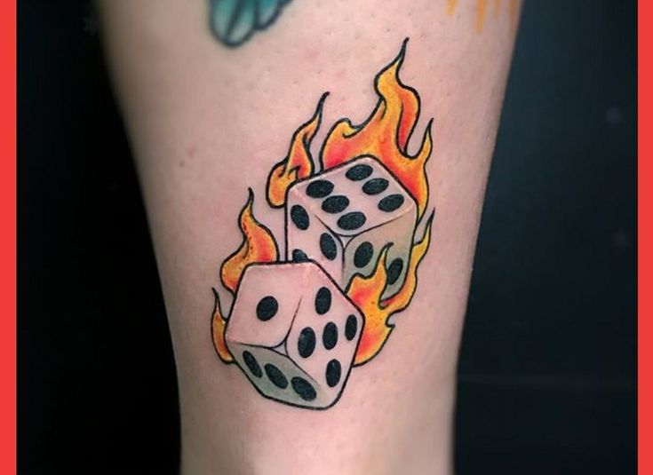 a close up of a person's foot with dices on fire and butterflies