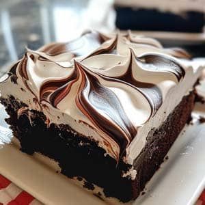 a piece of chocolate cake sitting on top of a white plate next to a red and white checkered table cloth