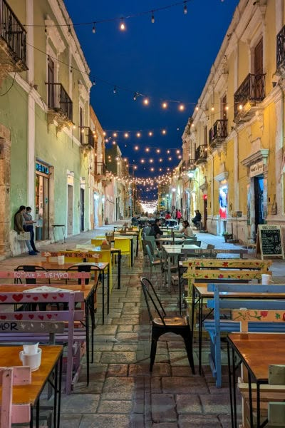 an empty street lined with tables and chairs